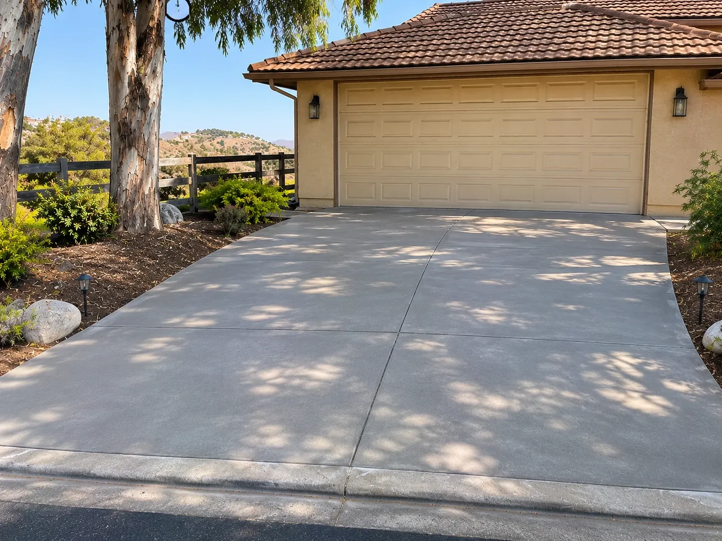 After: repaired and resurfaced concrete driveway with clean joints in front of the garage