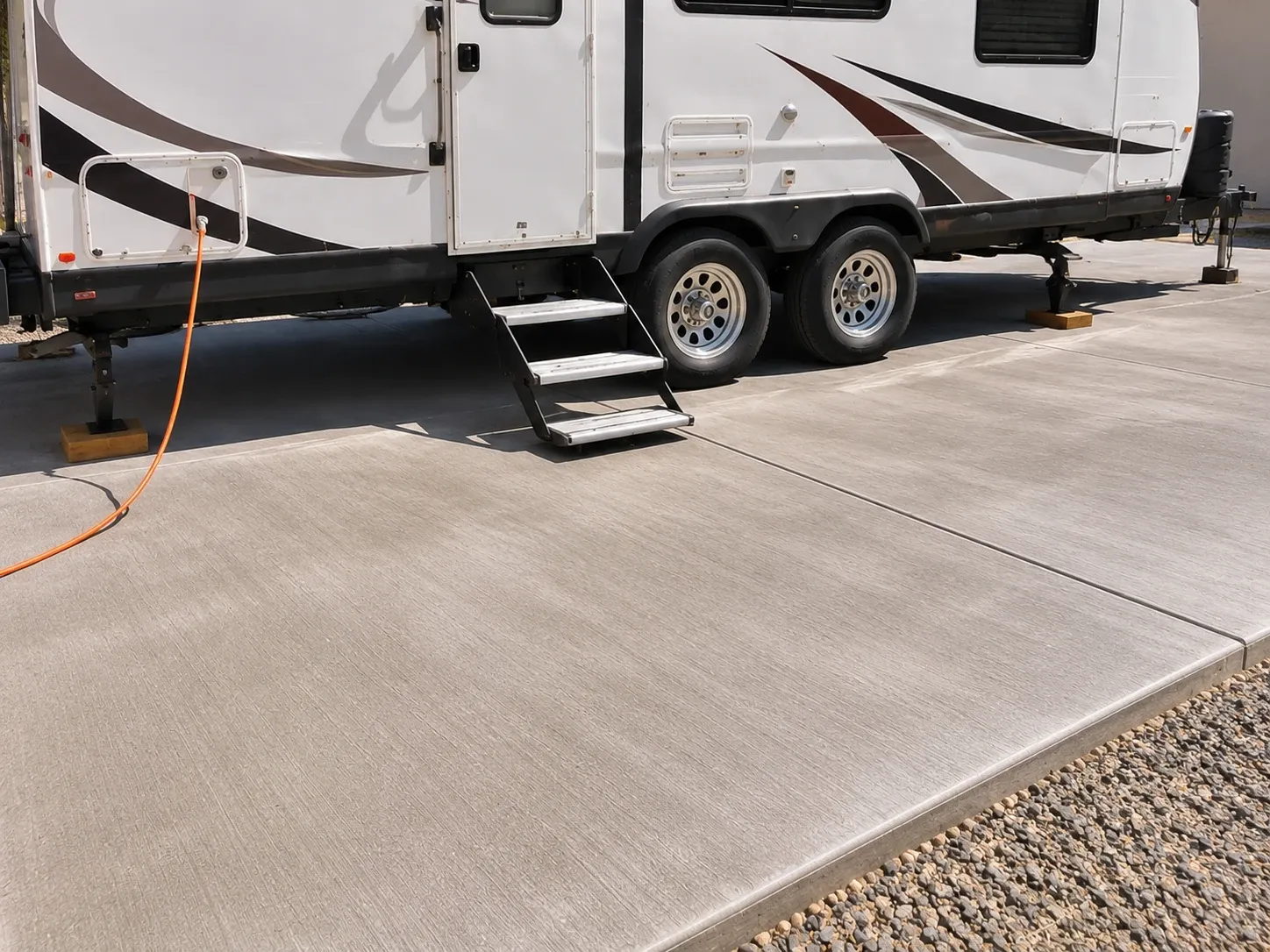 After: travel trailer parked on a new broom-finished concrete RV pad