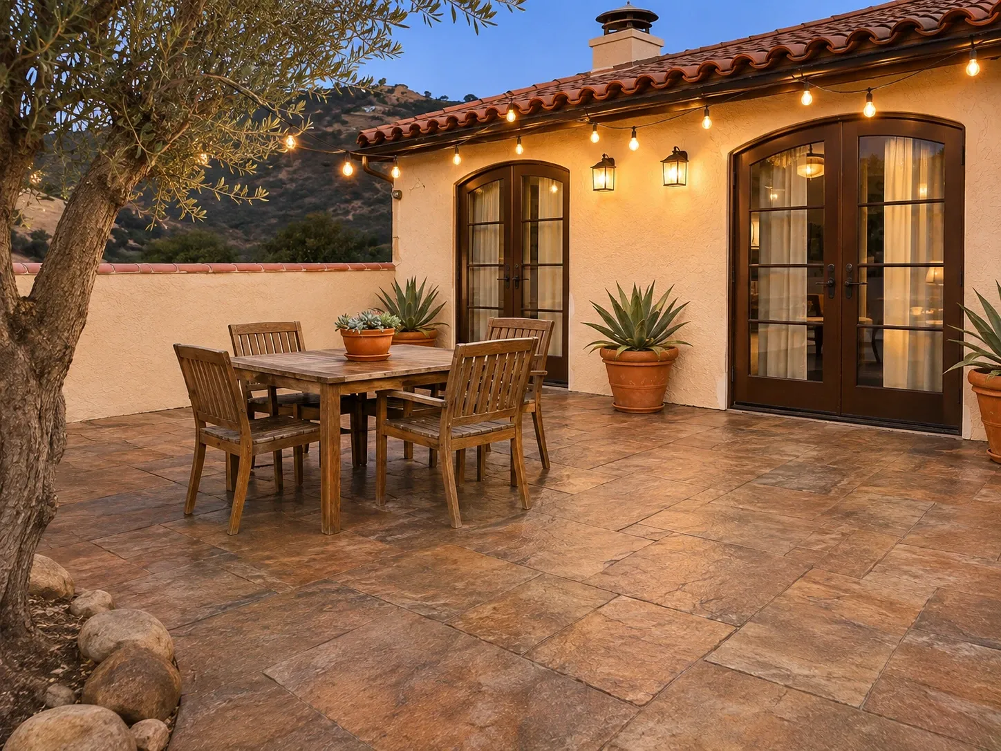 After: new slate-pattern stamped concrete patio outside a Spanish-style home at dusk